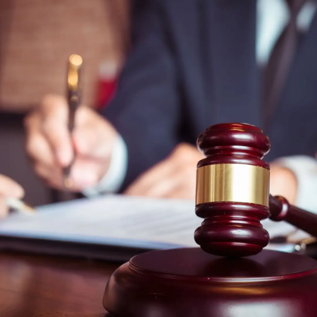 An IP lawyers gavel hammer with IP lawyer in the background