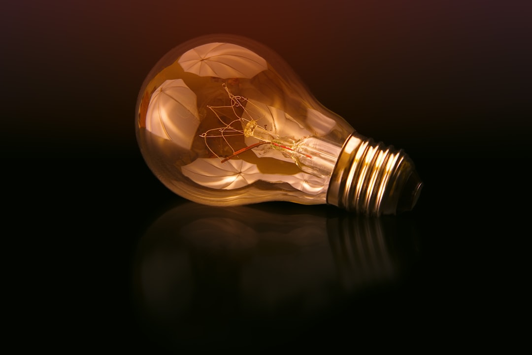 Orange tinted lightbulb on a black background